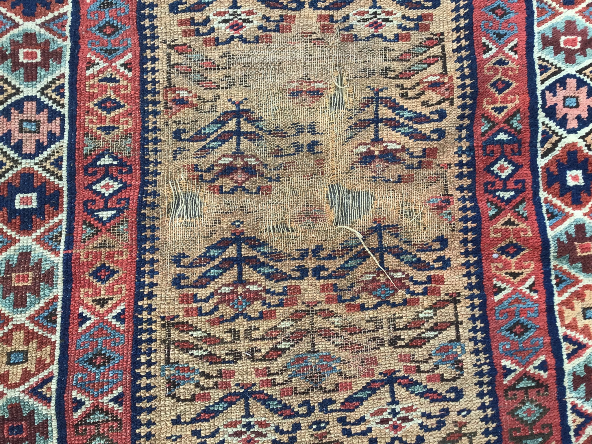 An antique Caucasian brick red ground runner, 410 x 100cm